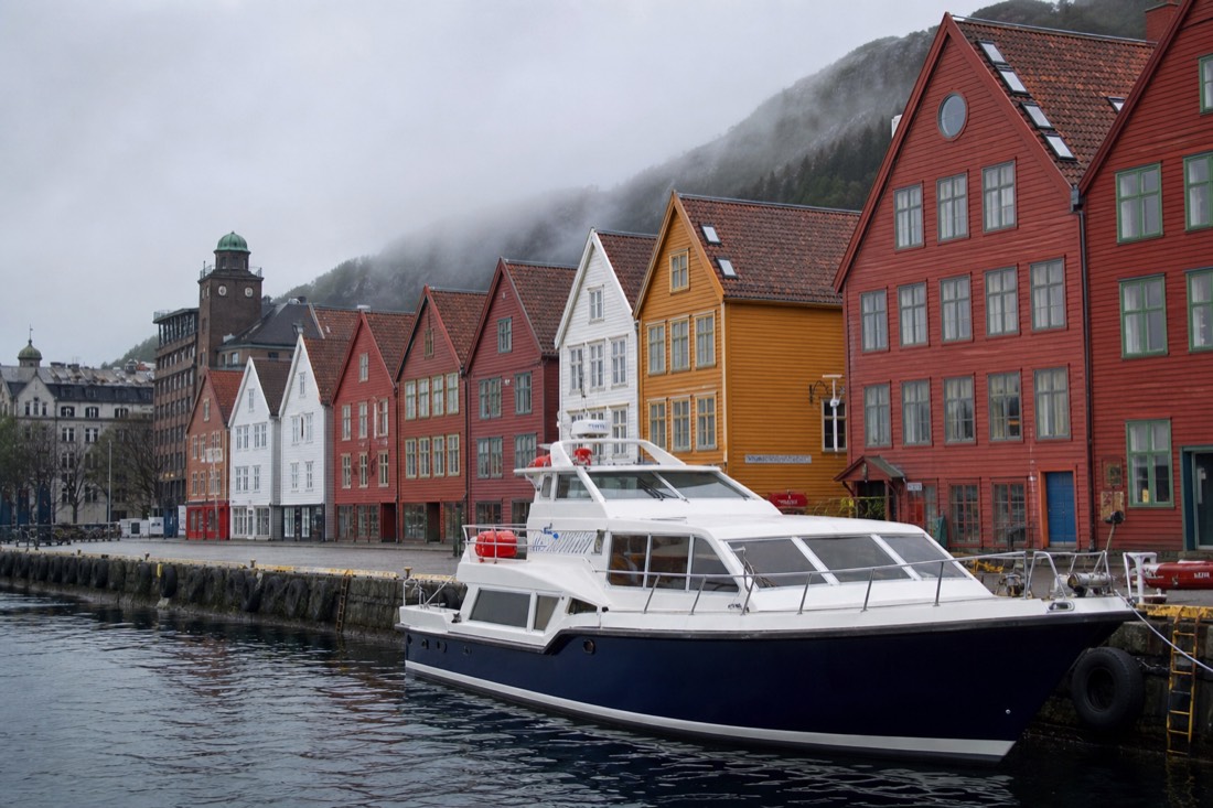 Sightseeing boat moored at the Bergen waterfront with colourful wooden facades behind