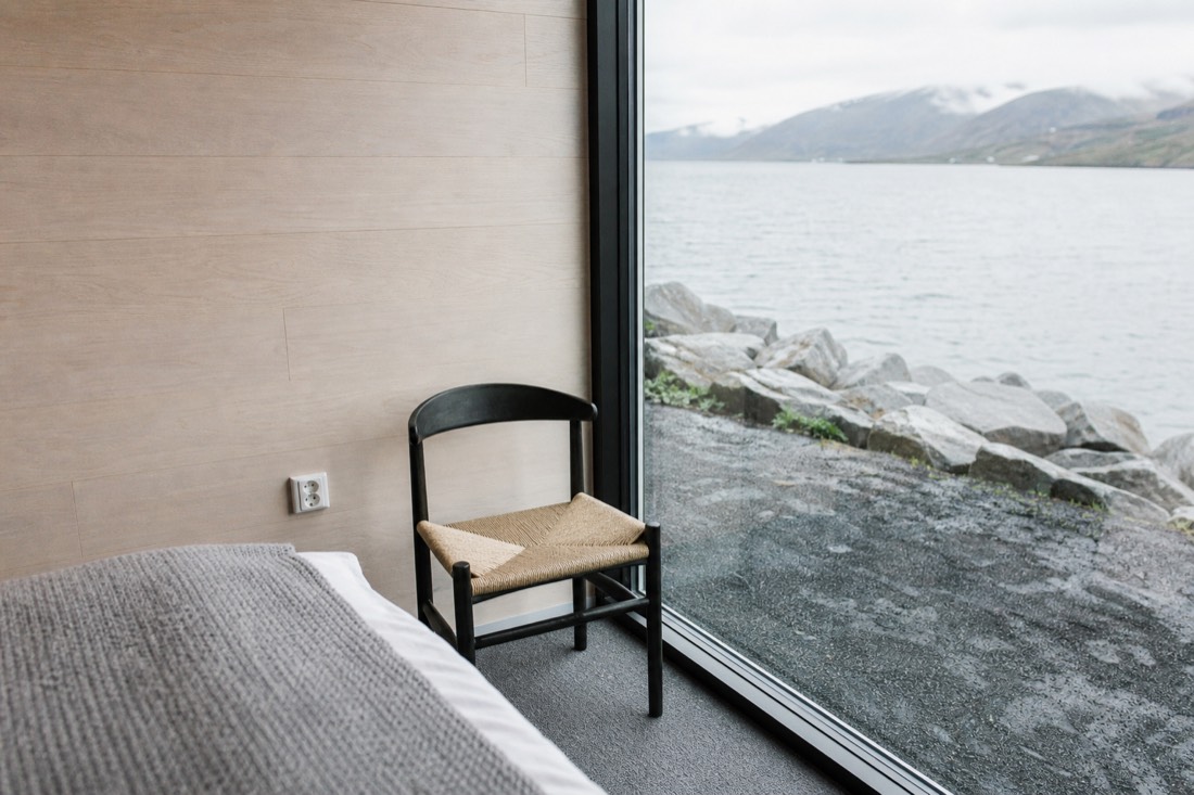 European round two-pin wall socket in a modern Nordic hotel room with pale wood panelling